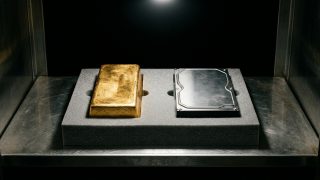 Sovranità digitale: un lingotto d'oro e un hard disk affiancati nella stessa teca di un caveau, custoditi con la stessa cura